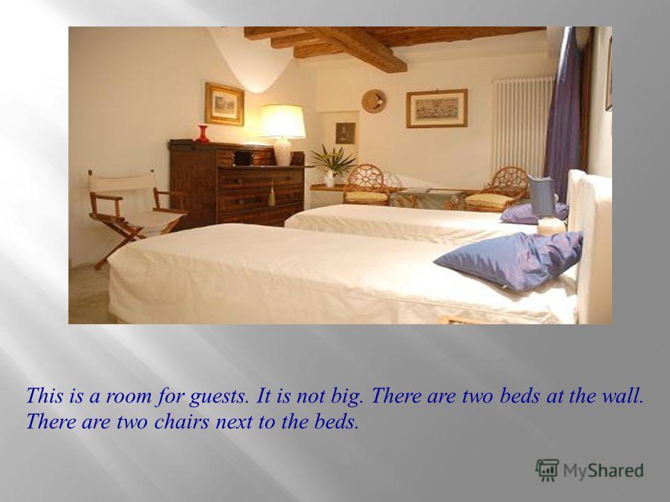 This is a room for guests. It is not big. There are two beds at the wall. There are two chairs next to the beds.